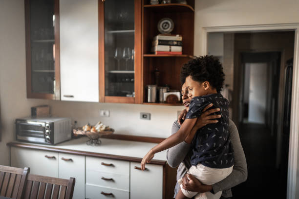 istock Mother carrying injured son 1267143633