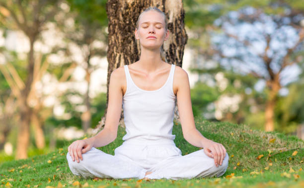 istock Serene young woman meditating at peace while sitting on the grass. 1267144780