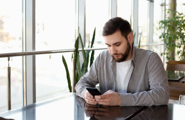 istock Phone conversation. Portrait smiling smart beard man in modern office with smartphone, texting messaging on application, check email, browsing internet web. Attractive businessman freelancer in cafe 1267145746