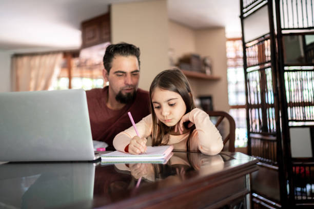 istock Father helping daughter with homework at home 1267148577