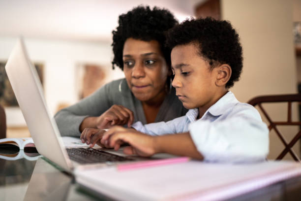 istock Mother helping son while he is studying on laptop at home 1267149797