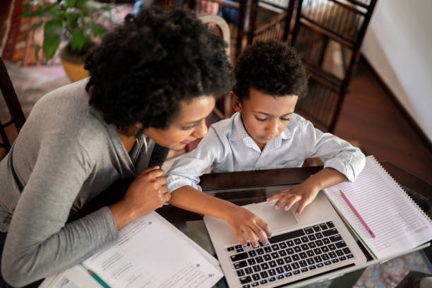 istock Mother helping son while he is studying on laptop at home 1267150615