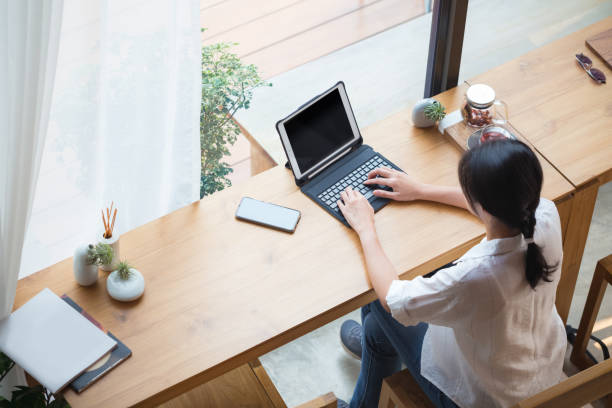 istock top back of woman working on tablet besides window in cafe 1267150768