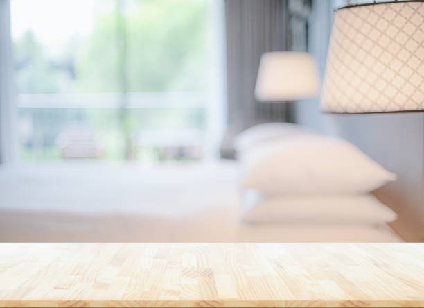 blurred bedroom interior background and wooden table top in front  for montage or display your products stock photo