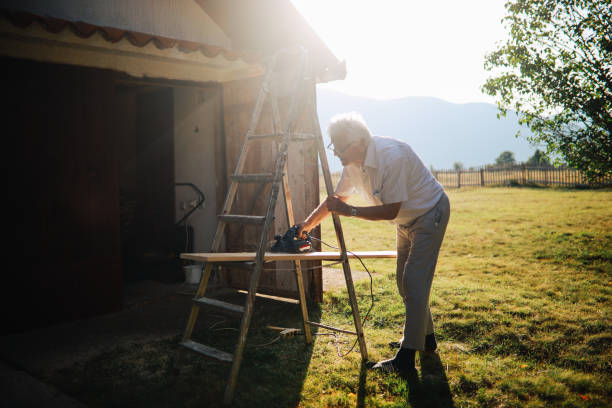Senior man doing works around the house, sanding wooden bars.