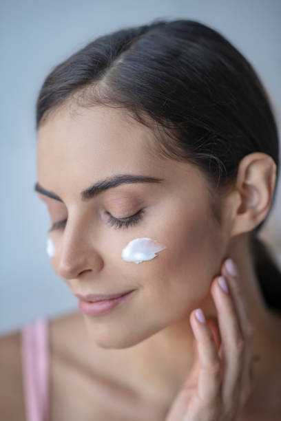 istock Woman putting a daily cream on her cheeks 1267152685