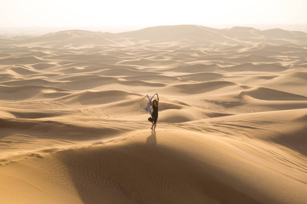 istock Girl dancing with a white cloth in the desert. 1267152841