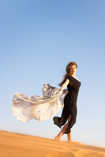 istock A lonely girl goes down the sand dunes. 1267152923