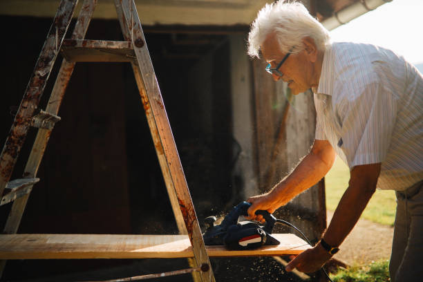 istock Senior man sanding wood for the floor on his weekend house 1267153207