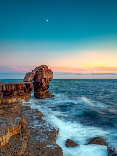 Moon over Pulpit Rock Moon capture over Pulpit Rock in Portland England bill of portland stock pictures, royalty-free photos & images