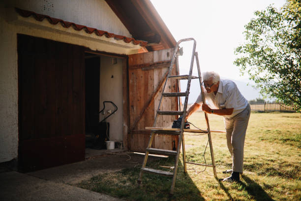 Senior man doing works around the house, sanding wooden bars.