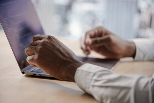 istock A man in a shirt is typing the text of a computer program on his laptop 1267159516