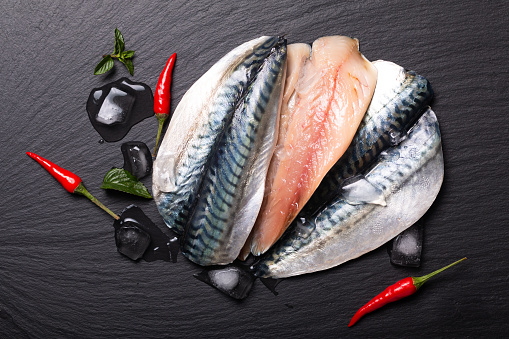 Seafood concept Fresh filet mackerel fish on black slate board with copy space