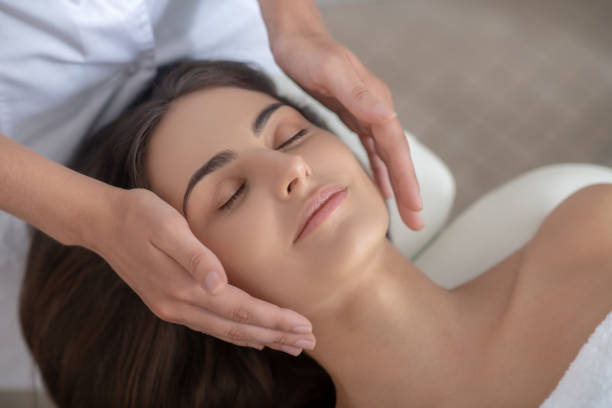 istock Professional massage therapist doing face massage to a customer 1267161420