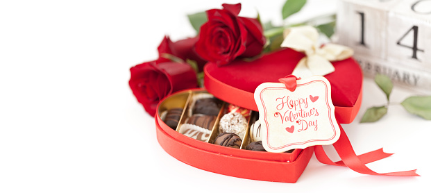 Valentine's Day heart shaped box of chocolates and red roses on white with a gift tag