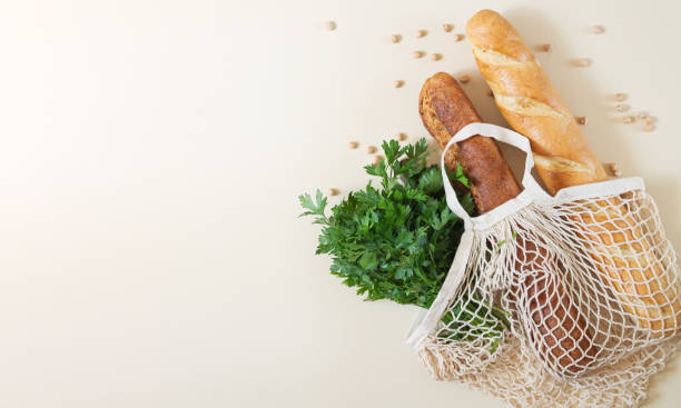 istock Mesh shopping bag with baguettes and fresh herbs top view with space for your text 1267164276