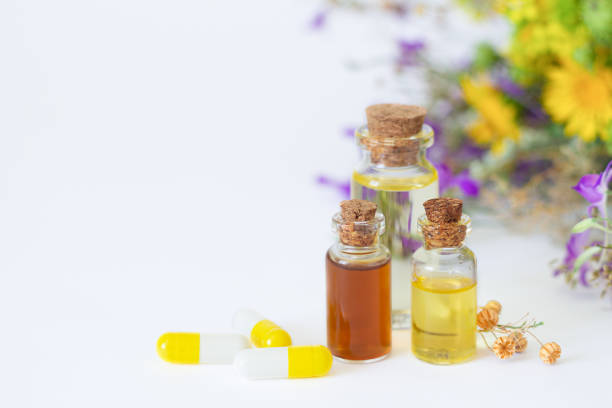 istock Bottles of essential oils next to herbal capsules on wtite background with copy space 1267164288