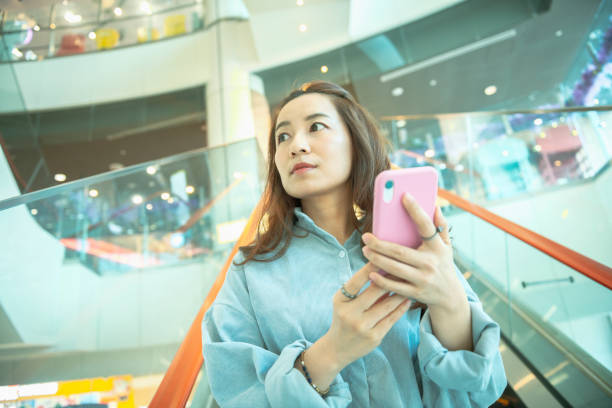 istock Woman using smartphone in the mall 1267165542