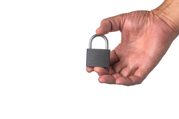 istock Male hand isolated on white background holds a padlock. 1267165592