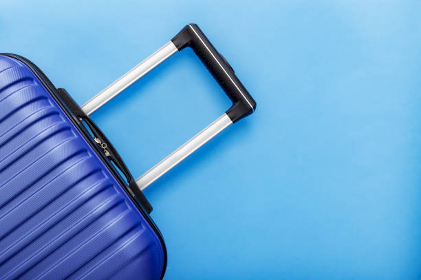 istock Modern Phantom Blue classic blue suitcase on blue background close up with copy space for text. Minimal style travel concept. Vacation trip. Summer holiday stock photo. Trendy color 2020 classic blue 1267165756