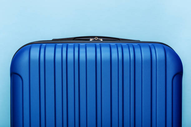 istock Modern Phantom Blue classic blue suitcase on blue background close up with copy space for text. Minimal style travel concept. Vacation trip. Summer holiday stock photo. Trendy color 2020 classic blue 1267165757