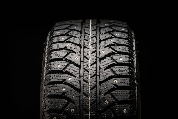 istock new winter studded tire close-up on a black background, front view 1267165795