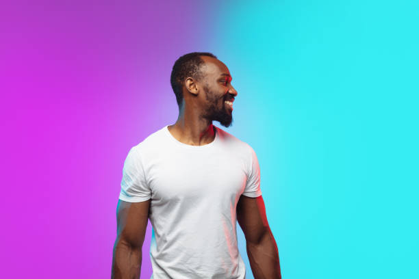 istock African-american young man's portrait on gradient studio background in neon 1267165798