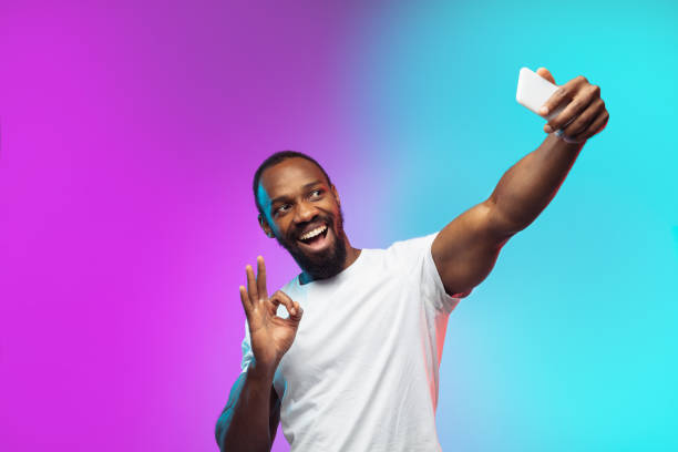 istock African-american young man's portrait on gradient studio background in neon 1267165805
