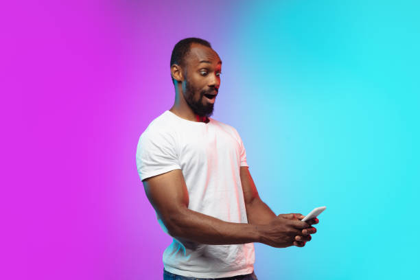 istock African-american young man's portrait on gradient studio background in neon 1267165812