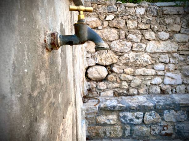 istock Vintage faucet on old exterior wall. 1267168861