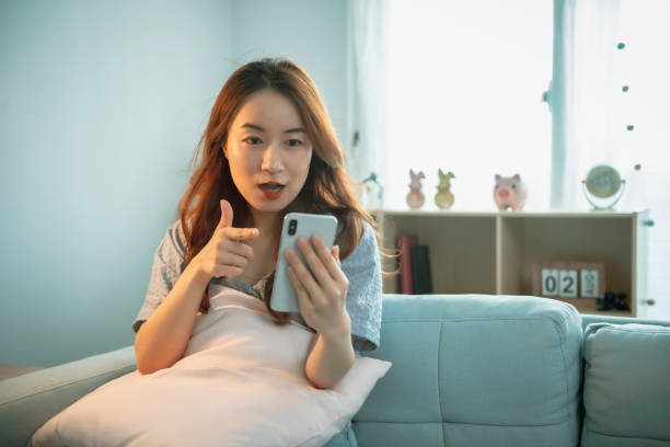 istock Woman Sitting On Sofa Couch Using Mobile Cell Phone 1267168880