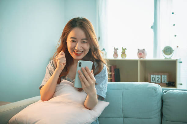 istock Woman Sitting On Sofa Couch Using Mobile Cell Phone 1267169065
