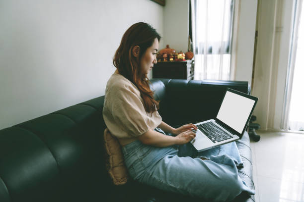 istock Asian woman using laptop computer to work at home 1267170419