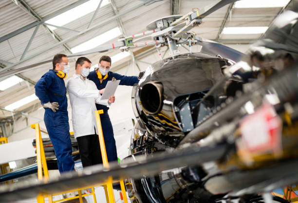 istock Group of mechanics wearing facemasks at work while doing an inspection on a helicopter 1267170494