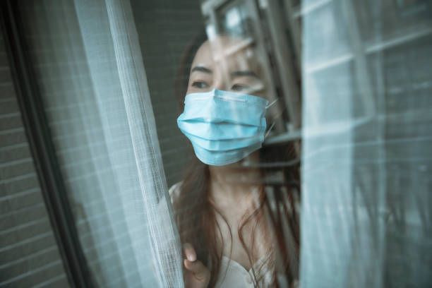 istock Woman wearing mask at home during isolation 1267170587
