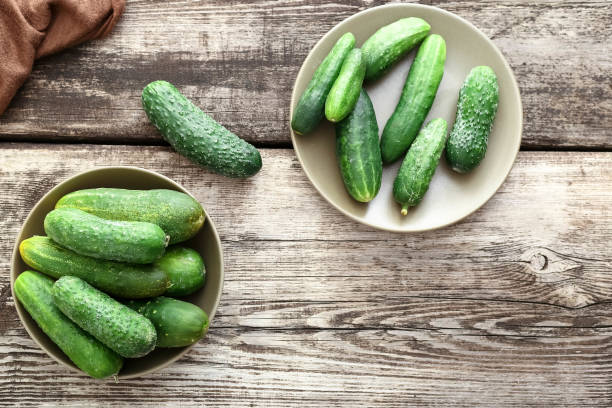 istock Fresh green cucumbers on a wooden rustic table. Copy space Flat lay Top view 1267172888