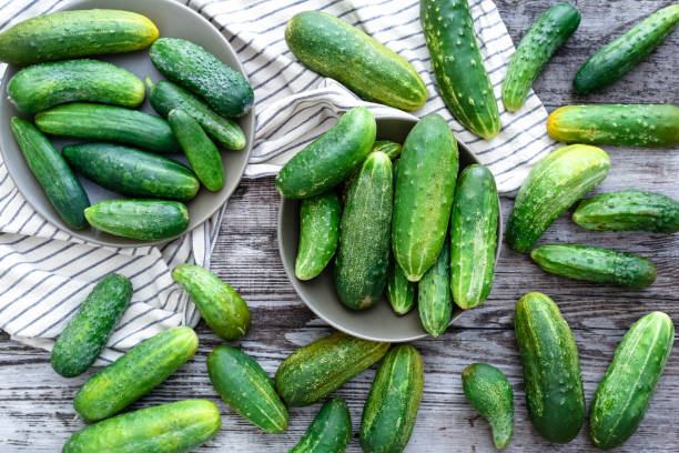 istock Fresh green cucumbers on a wooden rustic table. Flat lay Top view 1267172890