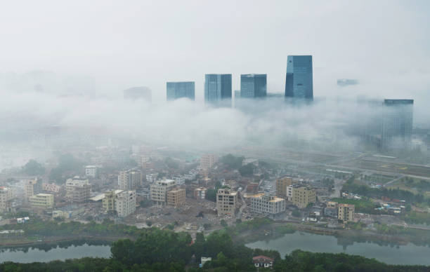 городские здания, покрывающие туманом утром - winter china cloud lake стоковые фото и изображения