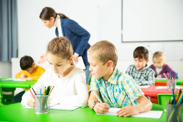 istock Happy pupils chattering sitting at lesson in elementary school 1267174804