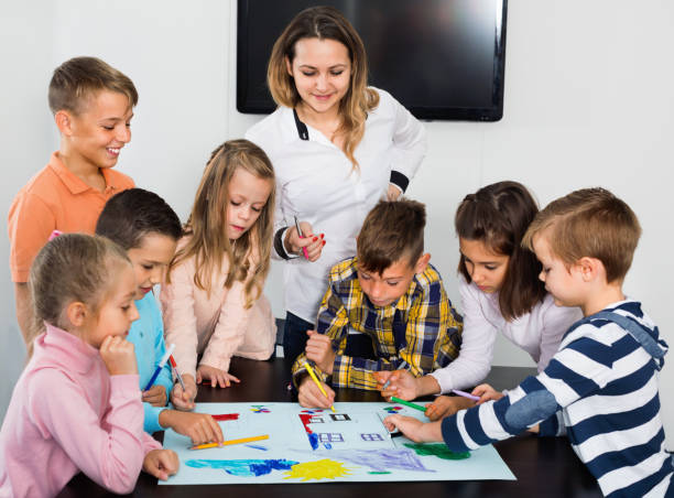 istock Children with teacher drawing together in classroom 1267176980