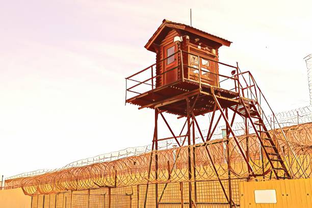 istock Prison tower and barbed wire fence 1267178325