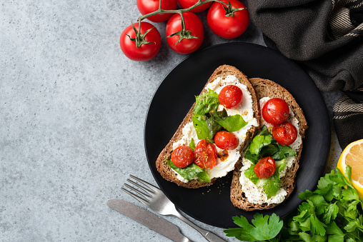 Italian bruschetta with ricotta cheese and tomatoes. Top view copy space for text