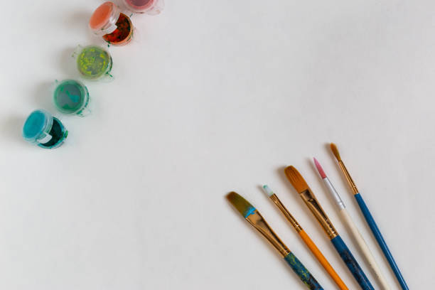 istock Paint brushes and acrylic paint on white background 1267180154