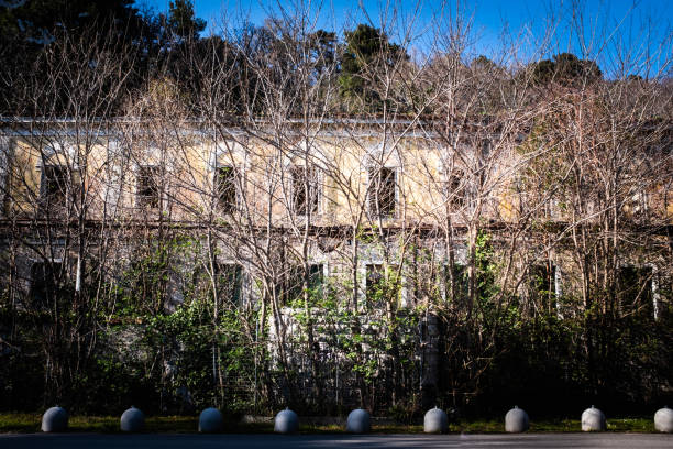 istock Lost place abandoned old hotel ruin behind fence and trees 1267181566