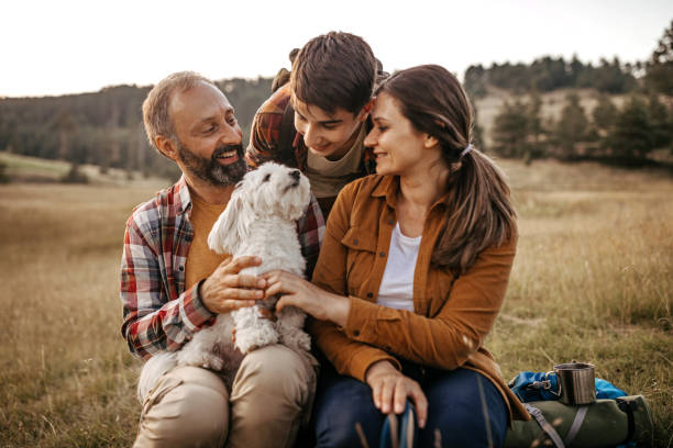 istock Family with pet dog relaxing while hiking at forest 1267185135