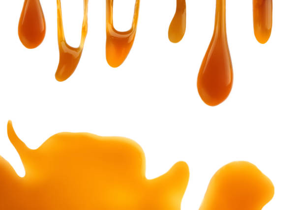 istock Spilled  melted caramel sauce isolated on white background. Flowing honey with Copy space. 1267186154