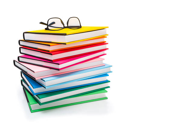 istock Stack of multicolored books and glasses isolated on white background 1267186257
