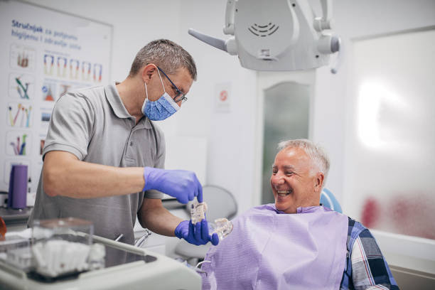 dentista explaning dentadura dentadura dentadura de trabajo a pacientes mayores felices - dentists chair fotos fotografías e imágenes de stock