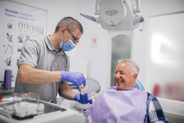 dentist explaning denture work to happy senior patient - dentists chair fotos imagens e fotografias de stock