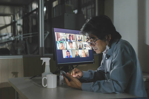 istock Solo worker looking at his smartphone screen while attending to a group video conference meeting in the office, with remote team colleagues 1267187239